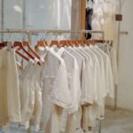 Araras com roupas organizadas por cor em uma loja de roupas